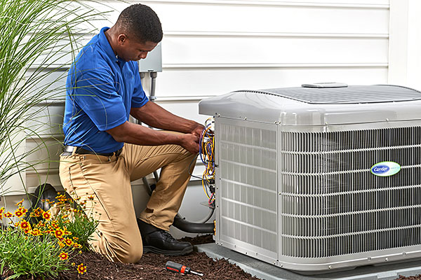 A man working on an air conditioner outside.