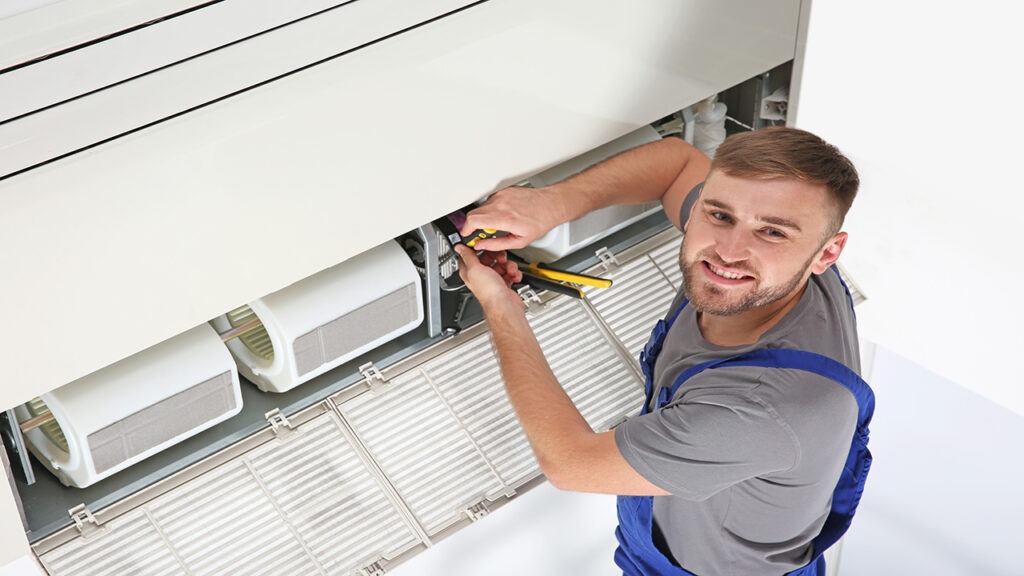 A man is working on an air conditioner.